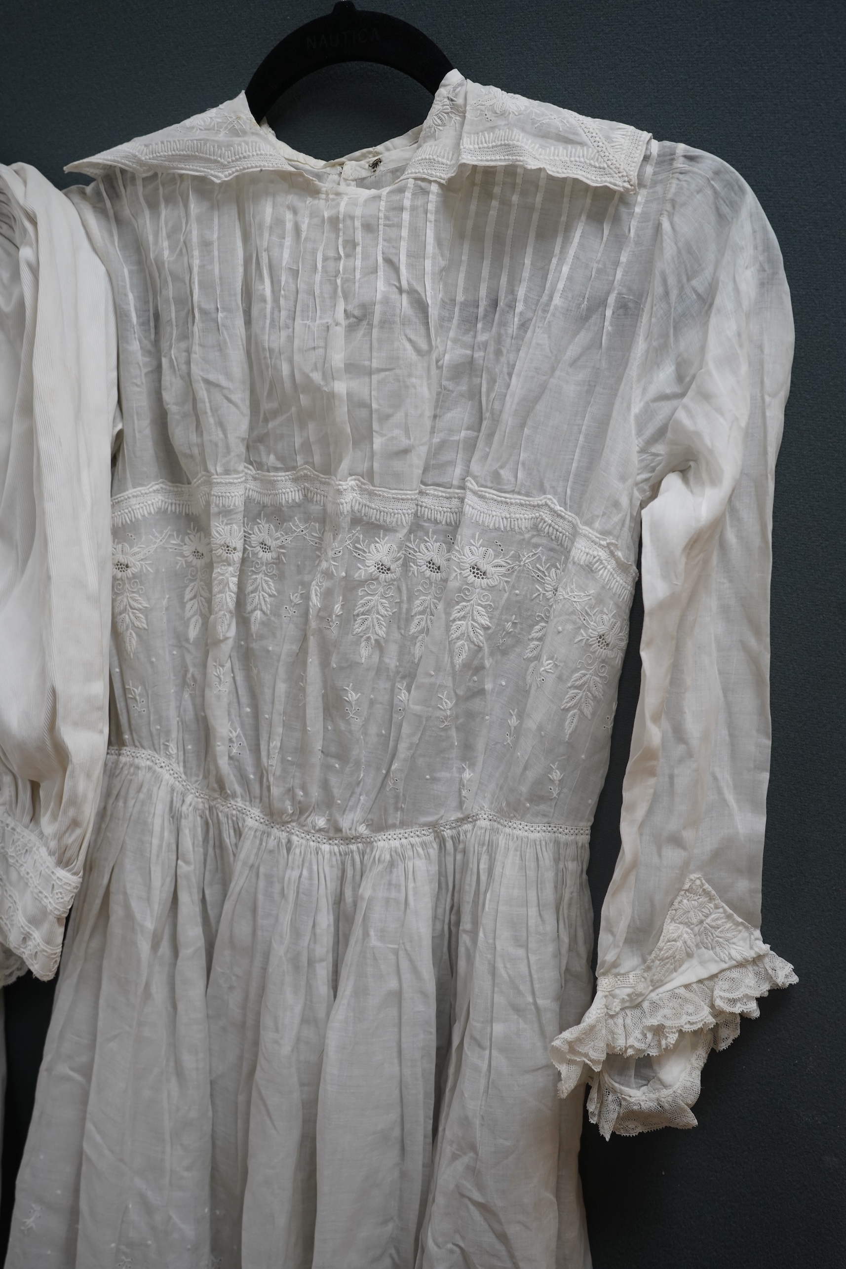 Two late 19th early 20th century girls summer dresses, one fine cotton with white worked collar cuffs and bodice, the other a cotton twill with anglaise collar large puff sleeves and gathered across the chest, lawn dress